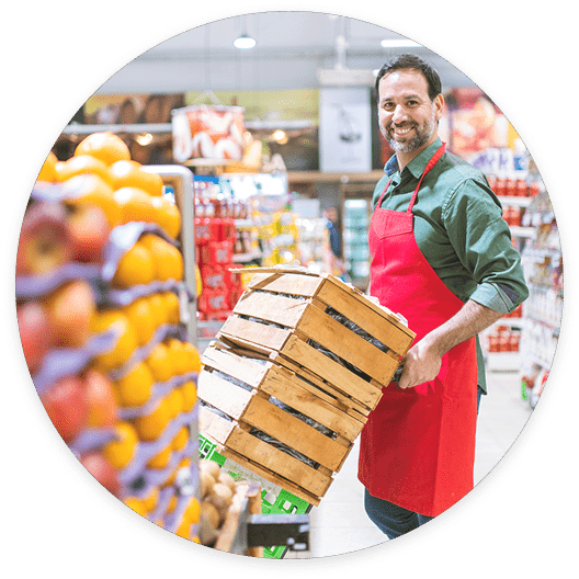 A worker arranges fruit in a supermarket