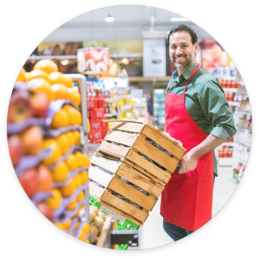 A worker arranges fruit in a supermarket